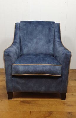 Fauteuil in blauwe velours met contra biezen. Vaste strakker rug met arm en los kussen