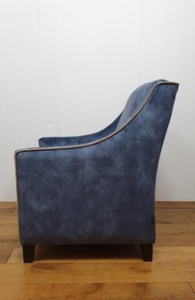 Fauteuil in blauwe velours met contra biezen. Vaste strakker rug met arm en los kussen