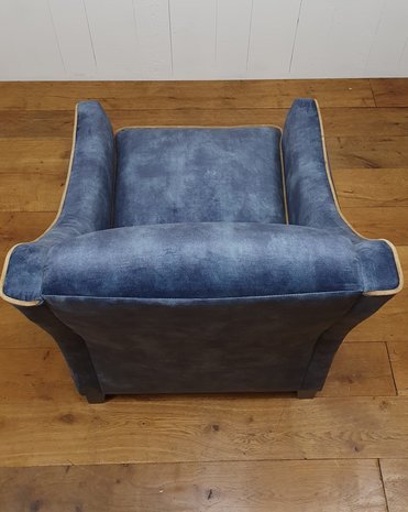 Fauteuil in blauwe velours met contra biezen. Vaste strakker rug met arm en los kussen